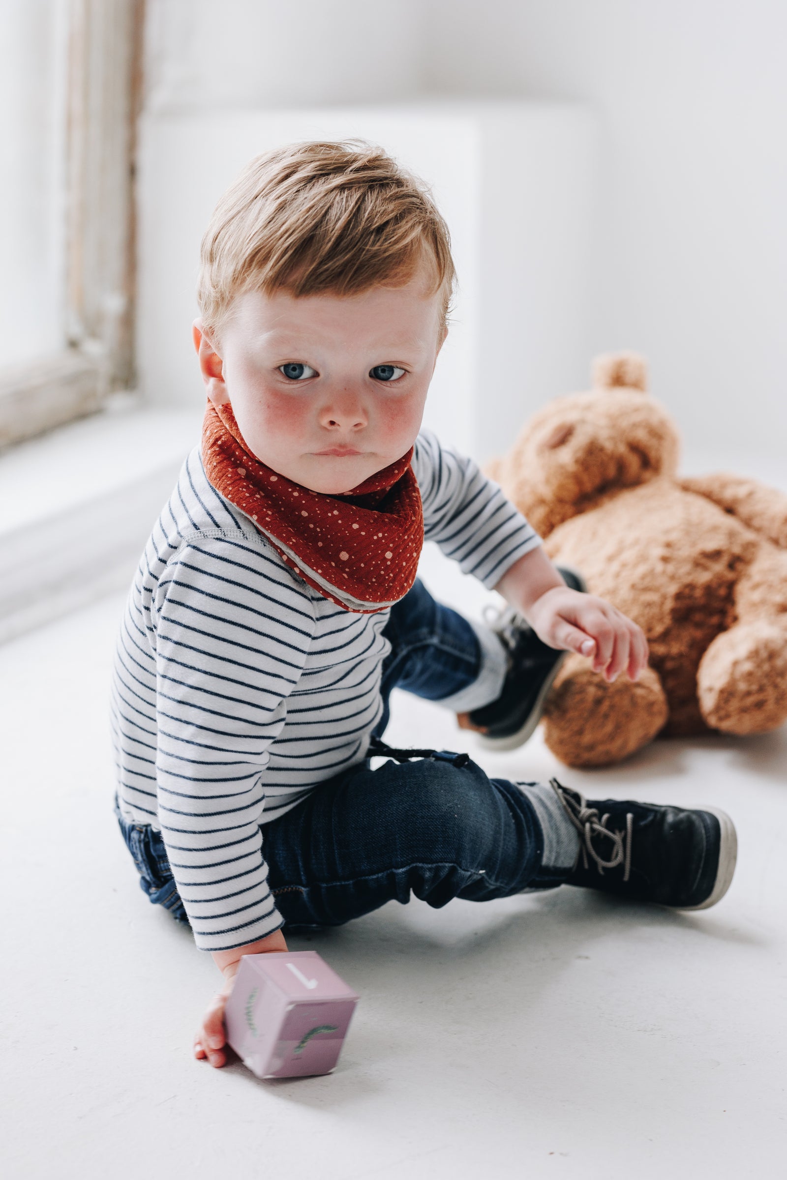 Close-up of a baby with a bib featuring a playful pattern.